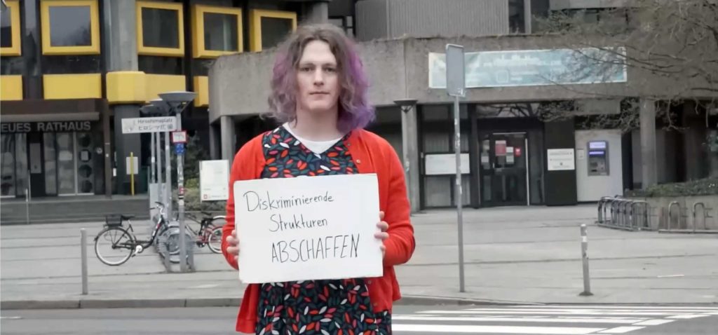 Equity Hannover, Person mit Demoschild "Diskriminierende Strukturen abschaffen"
